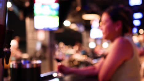 a woman sipping wine in a lively bar