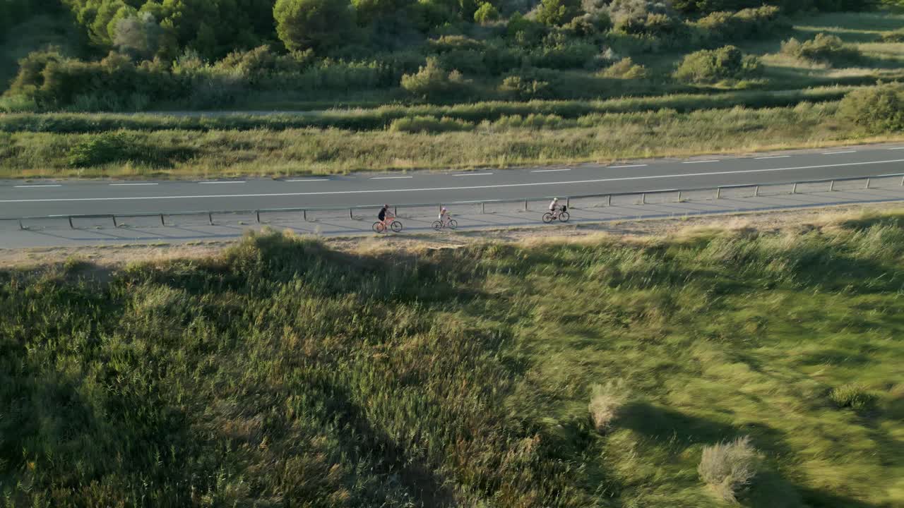 Aerial follow up shot of cyclists cycling on streets on a summer afternoon at Narbonne, France.