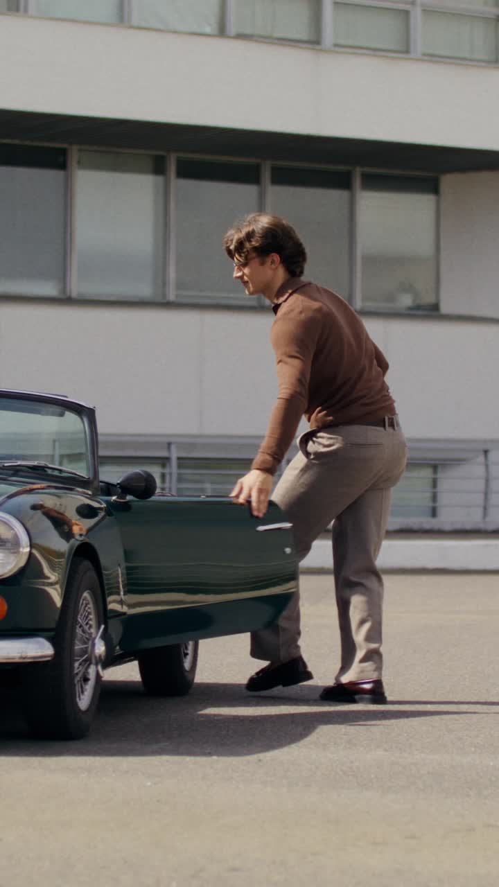 People loading a vintage convertible car at an airport