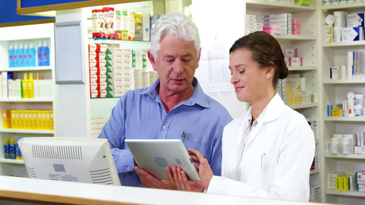 디지털 태블릿을 카운터에서 사용하는 약사들