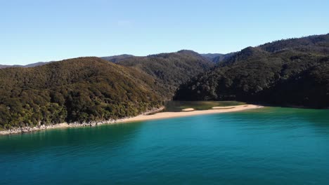 sandfly bay in abel tasman aerial fly backward shot, reveal of new zealand coast landscape