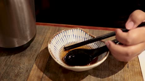 chopsticks and sauce interaction in a bowl