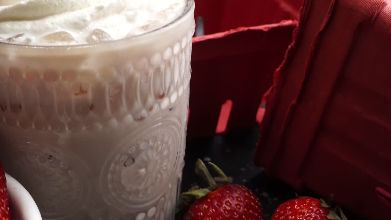 Pink cocktail drink with strawberry liqueur, vanilla vodka and cream. Party drink with strawberries. Fruit cocktail with fresh strawberries as a garnish. Cold and refreshing