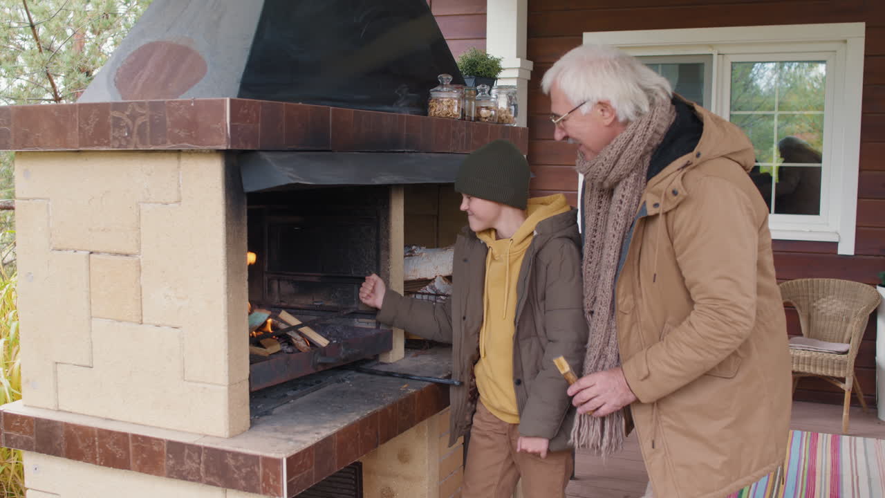 Grandfather and Child Kindling Outdoor Fireplace