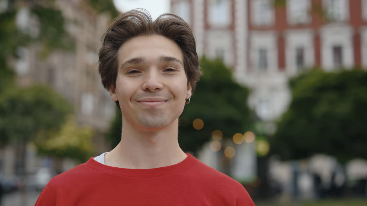 A young man in a red sweatshirt outdoors