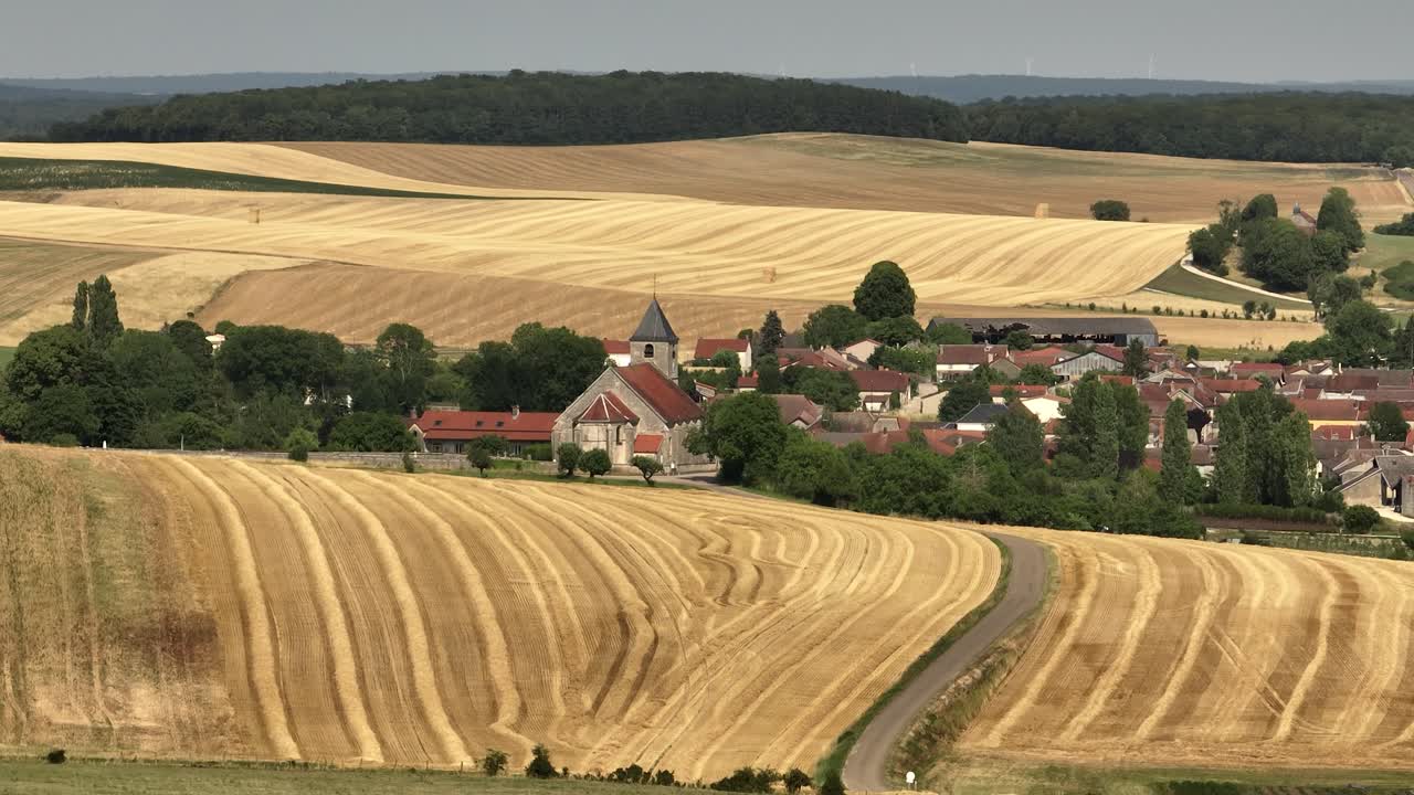 francia al este de la iglesia de la aldea campos de verano cosecha paisaje aéreo cámara lenta