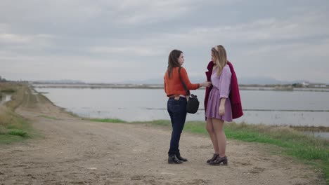 two friends talking by a lake