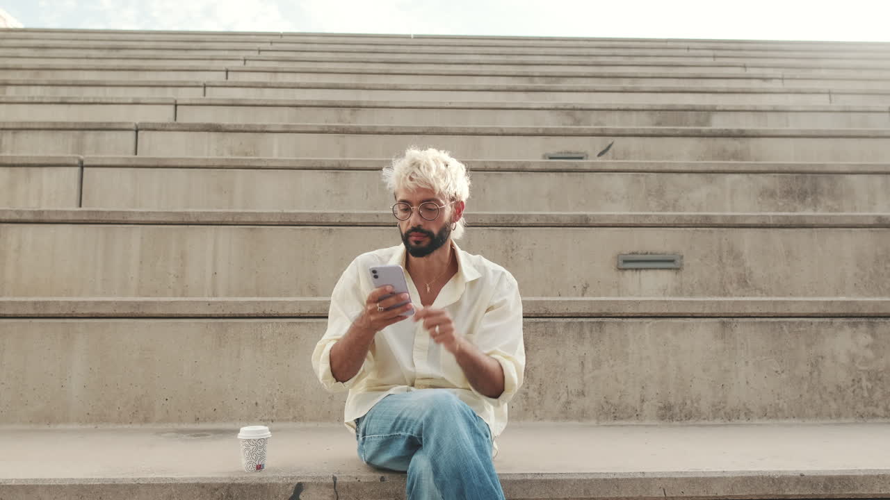 Uomo seduto sulle scale che usa il telefono