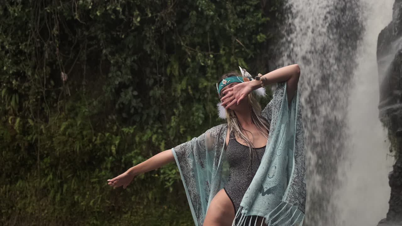 mujer en un vestido de estilo boho frente a una cascada