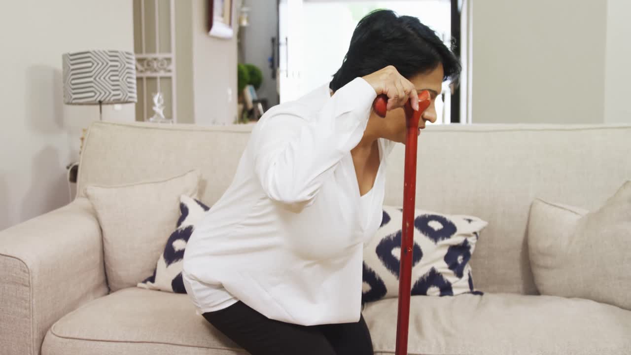 거실 4k의 소파에 앉아 있는 성숙한 여성