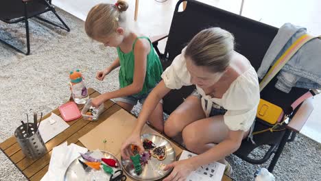 mother and daughter decorating cookies at a cafe