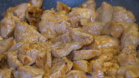 chicken pieces are being cooked in hot pan with oil bubbles and white steam