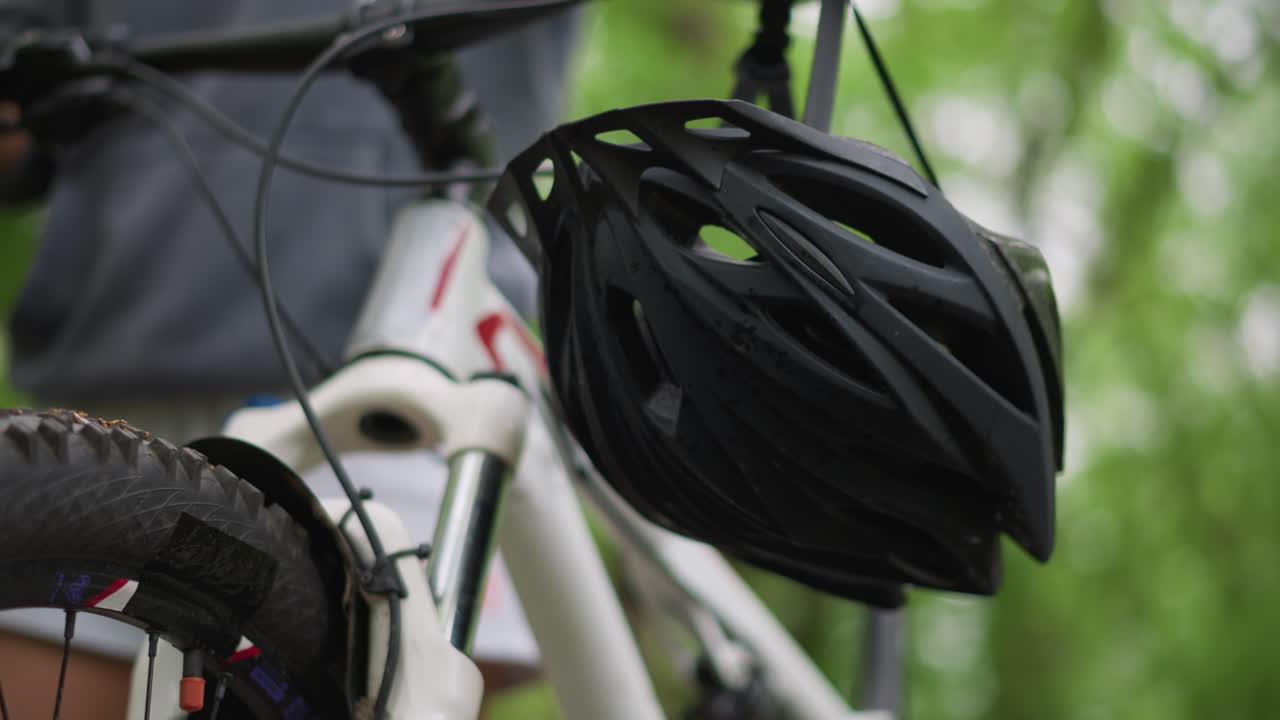 Bike Gear Detail, Closeup Of Helmet And Bike Features, Focus On Safety Equipment Beside Scenic Forest Setting, Detailed View Of Bicycle Helmet And Vents Against Tranquil Forest Backdrop