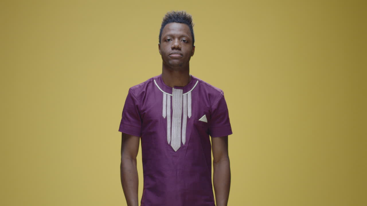 Man covering his eyes with his hand on a yellow background