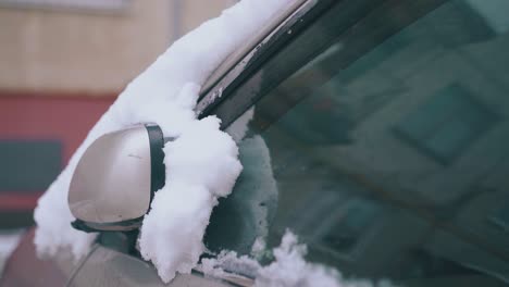 modern car with rearview mirror covered with thick snow