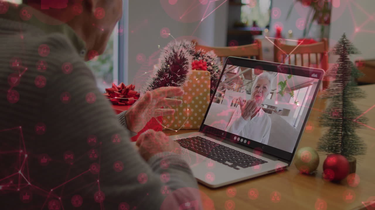Video chatting on laptop, elderly person with festive decorations in background