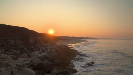 Einen-Sonnenaufgang-Am-Strand-Zwischen-Felsen-Entdecken