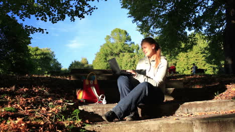 mujer joven trabajando al aire libre en una computadora portátil