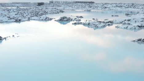 stunning blue lagoon pools reflect sky in snowy rugged landscape of iceland