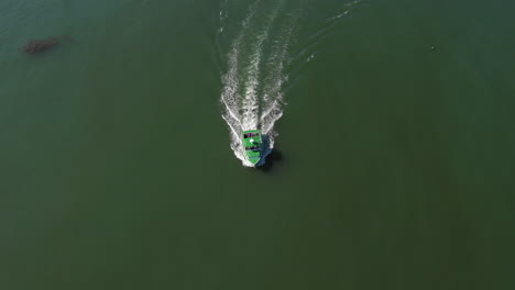 aerial high pan follow and reveal drone footage of green lobster boat approaching maine coast, vinalhaven, fox islands, knox county, maine, usa
