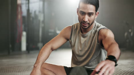 hombre estirándose en el suelo del gimnasio para un cuerpo fuerte