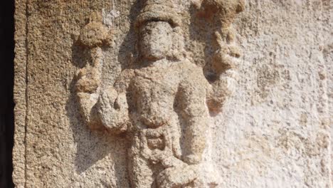 Captura-De-Seguimiento-Rápido-De-La-Figura-En-El-Costado-De-La-Columnata-Del-Antiguo-Templo-En-Hampi,-Karnataka,-India