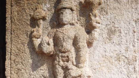 captura de seguimiento rápido de la figura en el costado de la columnata del antiguo templo en hampi, karnataka, india