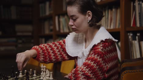 frau spielt schach in einer bibliothek