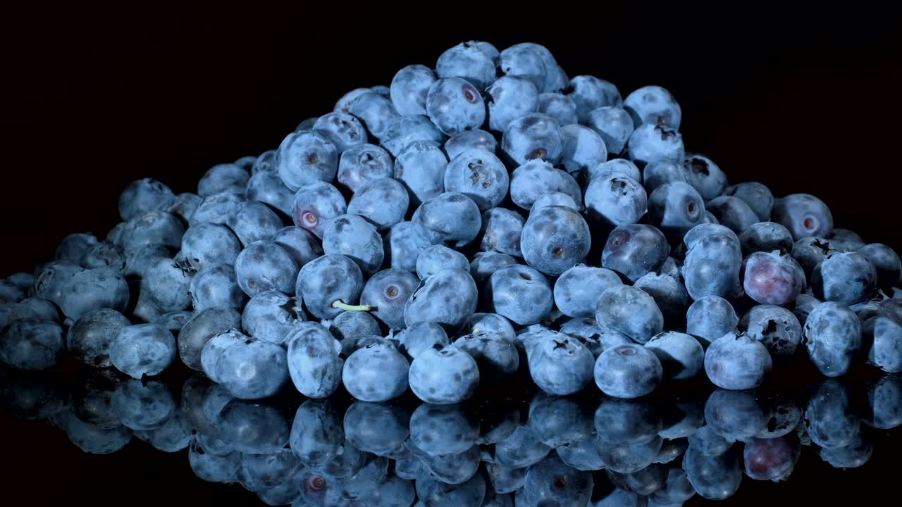 검은 유리판에 블루베리를 회전시켜 반사시. 클로즈업, 카메라 회전 360도. 보그 빌베리, 보그 블루베리, 노던 빌베리 또는 웨스턴 블루버리 (vaccinium uliginosum)