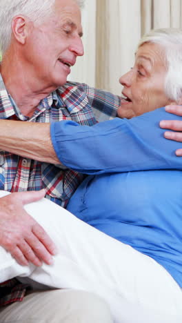 una pareja de mayores abrazándose en el sofá.