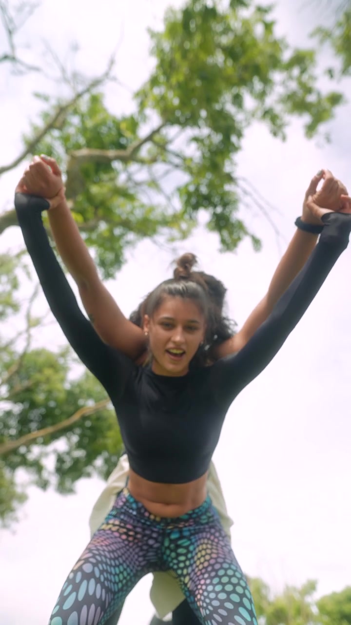 Two Young Women Performing Partner Acro Yoga Exercise Outdoors in a Park