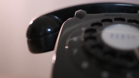 close-up rotating product shot of a retro-style black rotary dial phone