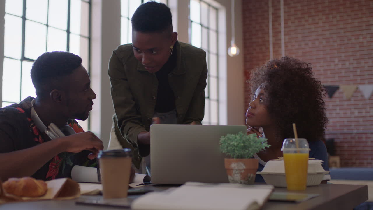 creative black business people meeting team leader woman training colleagues sharing ideas on laptop computer brainstorming in modern office workplace