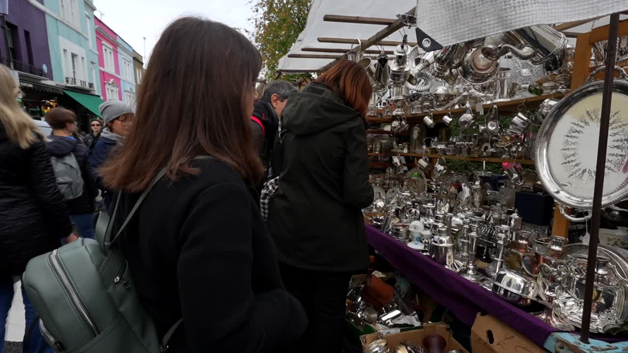 Tourists browse a stall with vintage items at Portobello Road Market in London