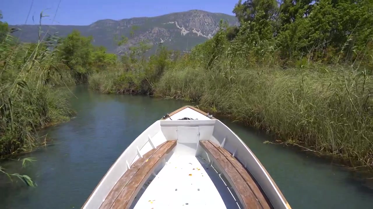 Piccola barca che naviga attraverso uno stretto canale fluviale