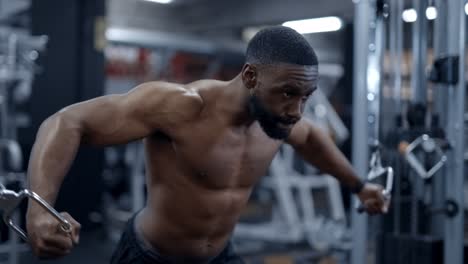 muscular african american man performs cable chest pulls