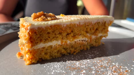 Tasty-slice-of-carrot-cake-with-a-walnut-on-a-plate,-sweet-dessert,-4K-shot