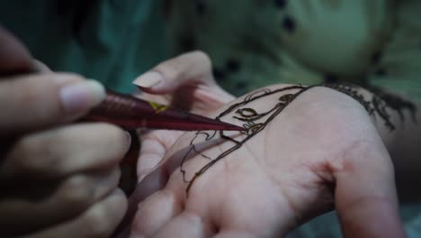 lady artist tattooing the palm of a young girl in agra city, state of uttar pradesh, india. - close up shot