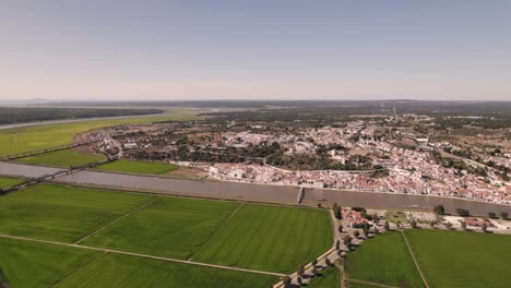 Beautiful-Portugal-town-surrounded-with-green-agriculture-fields,-high-angle-drone-view