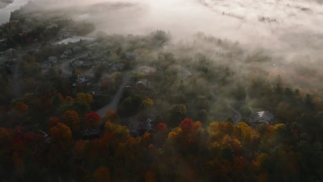 view from above of clouds moving over fall foliage in sherbrooke, quebec, canada at sunrise