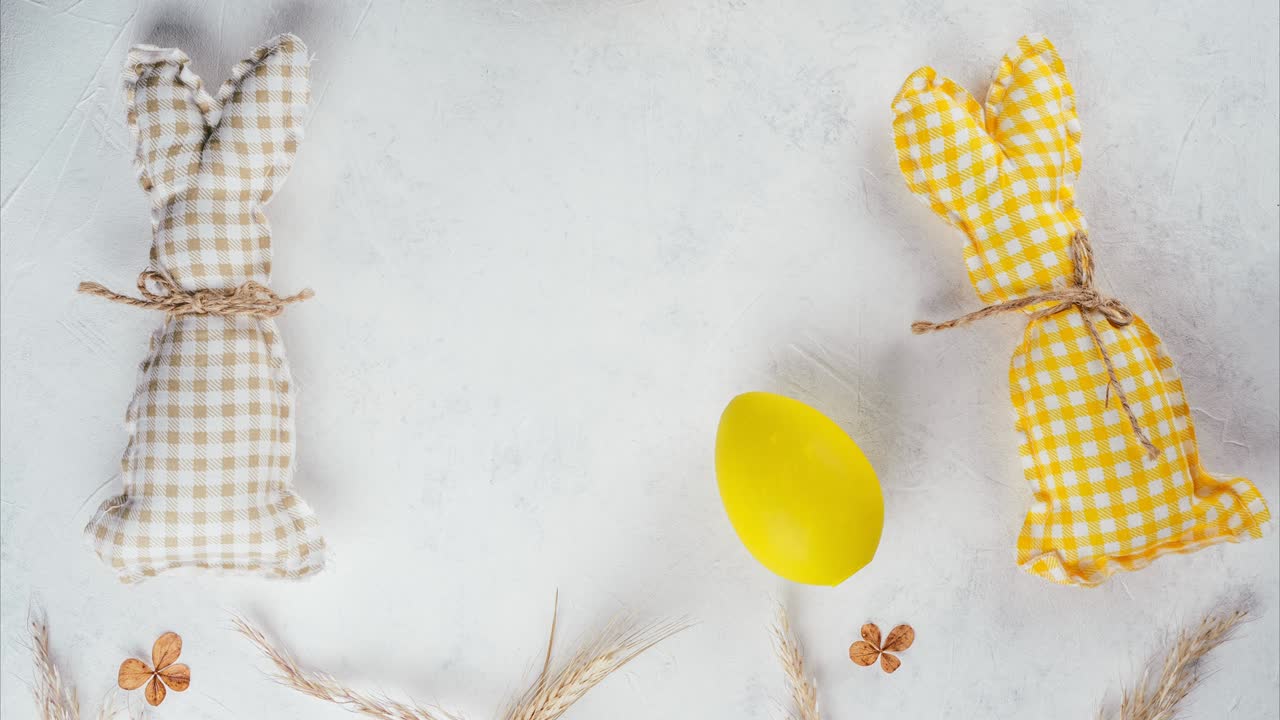 Stop motion Easter video of yellow and beige handmade bunnies pushing yellow Easter egg to each other playing football