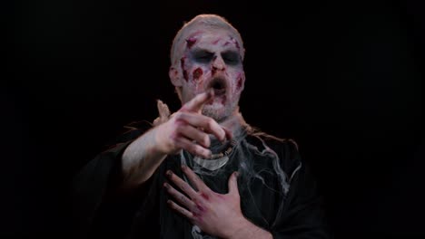 hombre zombie de halloween señalando con el dedo a la cámara, riendo en voz alta, burlándose haciendo una broma divertida