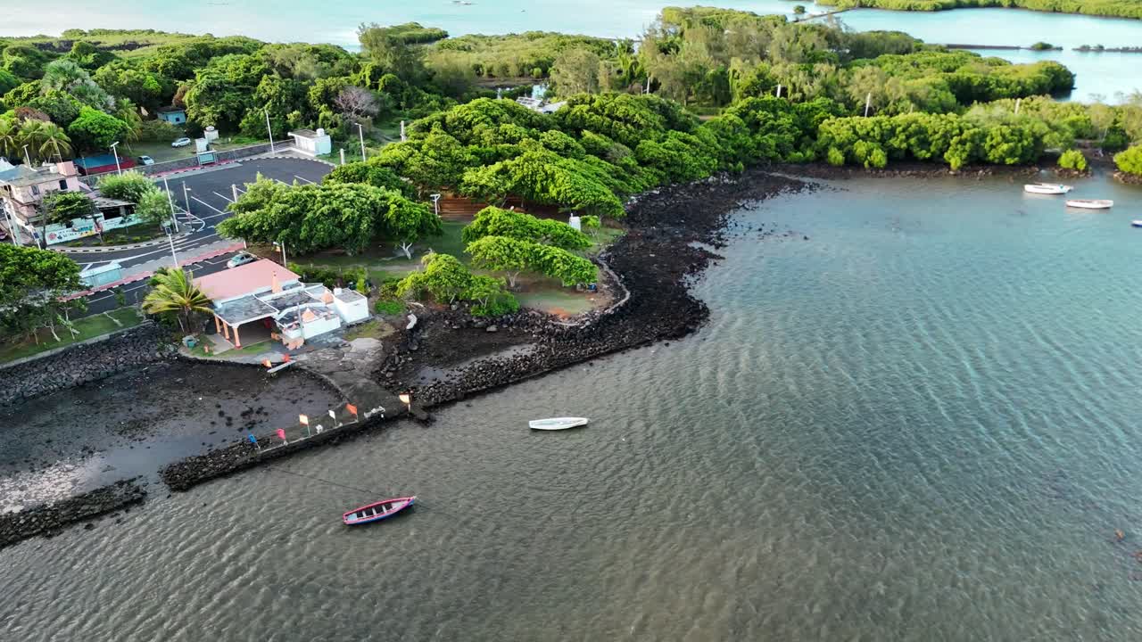 Temple by beach in Poudre d’Or, Mauritius shown from aerial view with palm trees and coastline