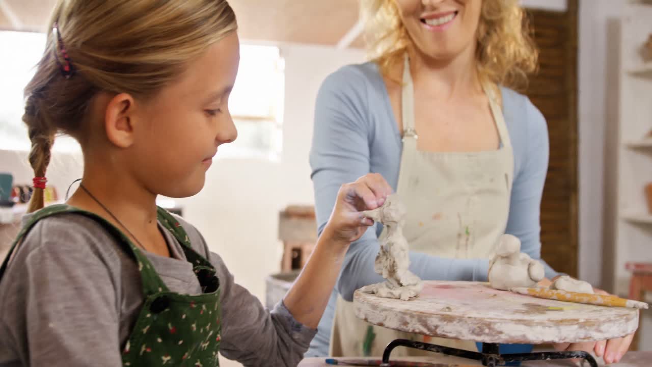 어머니 와 딸 이 점토 로 장난감 을 만들고 있다