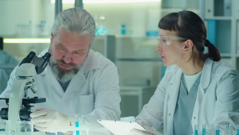 senior scientist working with young female colleague in lab
