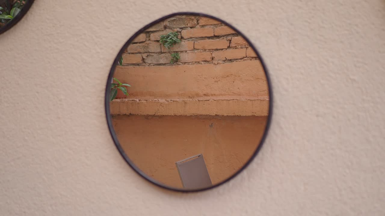 Riflesso in uno specchio rotondo su una parete texturizzata