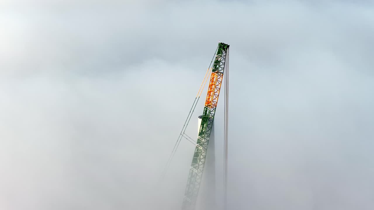 Crane pokes through thick cloud cover during wind farm development
