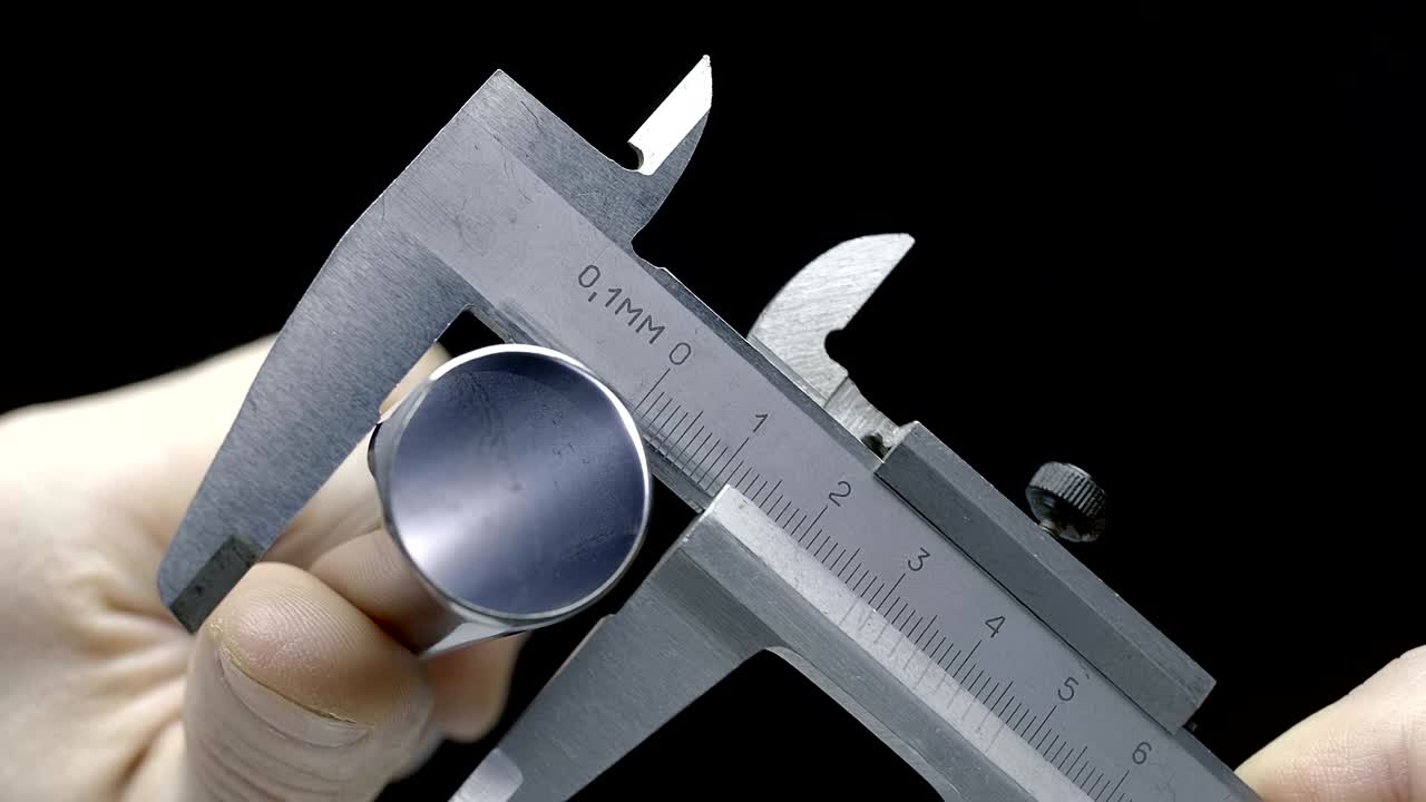 파이프의 지름을 고전적인 금속 칼리퍼로 측정합니다.