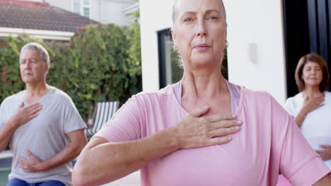 practicing yoga, senior friends doing breathing exercises in outdoor class