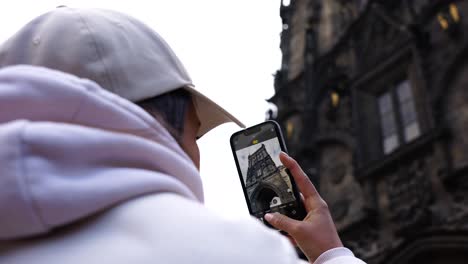 Female-tourist-take-photos-of-gothic-medieval-Powder-gate-exterior,-Prague